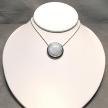 Load image into Gallery viewer, A fitting homage to the elegant and mysterious moon goddess Diana, this medallion style necklace features a weighty and luminous Moonstone cabochon bezel set and ringed with a wide band of solid silver. A sleek chain mounted directly to the edges of the pendant gives a clean finish and keeps the pendant centered.  A 16” chain ensures the pendant will lay comfortably just below your collarbones.