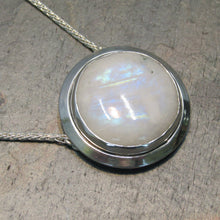 Load image into Gallery viewer, A fitting homage to the elegant and mysterious moon goddess Diana, this medallion style necklace features a weighty and luminous Moonstone cabochon bezel set and ringed with a wide band of solid silver. A sleek chain mounted directly to the edges of the pendant gives a clean finish and keeps the pendant centered.  A 16” chain ensures the pendant will lay comfortably just below your collarbones.