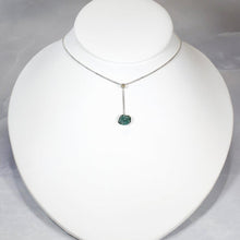 Load image into Gallery viewer, A rich green raw emerald dangles from a tiny glowing labradorite. This y-shaped necklace is perfect for deep necklines and adding the perfect amount of color without overwhelming your look!
