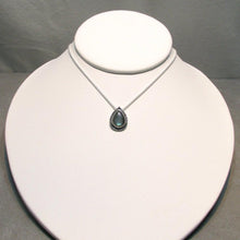 Load image into Gallery viewer, The Labradorite cabochon is absolutely stunning with its deep aqua and teal glow. A rounded offset halo with hand-carved details is oxidized for beautiful contrast. A hidden bail lets the pendant float on the chain with no visual clutter. Subdued enough to class up a t-shirt and jeans but elegant enough to pair with a black dress, this necklace is sure to be a favorite finishing touch!