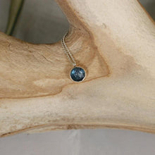 Load image into Gallery viewer, These sweet little pendant features an ethically sourced rosecut Teal Kyanite set in a simple recycled silver bezel. At 9mm wide, it is the perfect size for everyday wear while still adding a flash of sparkle to your look! This necklace pairs perfectly with the Luna Teal Kyanite Studs