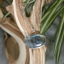 Load image into Gallery viewer, The Johnna necklace is minimal in form and maximal in impact. A delicate peaked silver band holds this large, flashy, aqua Labradorite in its rightful place, front and center. With plenty of color this piece will add glam to any look, while its soft turquoise and denim hues will be easy to style with your wardrobe staples.