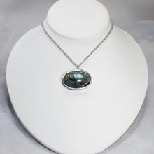 Load image into Gallery viewer, The Johnna necklace is minimal in form and maximal in impact. A delicate peaked silver band holds this large, flashy, aqua Labradorite in its rightful place, front and center. With plenty of color this piece will add glam to any look, while its soft turquoise and denim hues will be easy to style with your wardrobe staples.