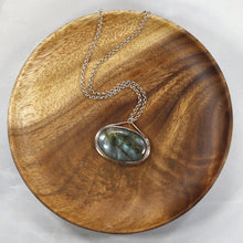 Load image into Gallery viewer, The Johnna necklace is minimal in form and maximal in impact. A delicate peaked silver band holds this large, flashy, aqua Labradorite in its rightful place, front and center. With plenty of color this piece will add glam to any look, while its soft turquoise and denim hues will be easy to style with your wardrobe staples.