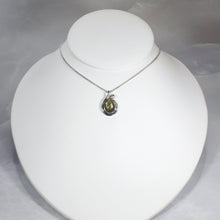 Load image into Gallery viewer, Tara evokes the new life of a seed just sprouted. A green-gold Labradorite is nestled in a tapered silver swirl and topped with a tiny dewdrop Labradorite.