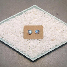 Load image into Gallery viewer, These sweet little studs feature ethically sourced rainbow moonstones set in a simple recycled silver bezel. At 9mm wide, they are the perfect size for everyday wear while still adding a flash of shimmer to your look! Solid sterling studs and surgical steel butterfly backings provide a secure fit for sensitive skin. These moondrops come in a range of colours from pearly white to twilight blue so you can pick your perfect pair!