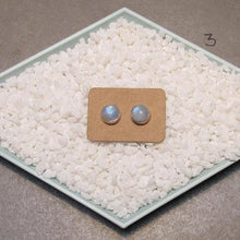 Load image into Gallery viewer, These sweet little studs feature ethically sourced rainbow moonstones set in a simple recycled silver bezel. At 9mm wide, they are the perfect size for everyday wear while still adding a flash of shimmer to your look! Solid sterling studs and surgical steel butterfly backings provide a secure fit for sensitive skin. These moondrops come in a range of colours from pearly white to twilight blue so you can pick your perfect pair!