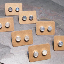 Load image into Gallery viewer, These sweet little studs feature ethically sourced rainbow moonstones set in a simple recycled silver bezel. At 9mm wide, they are the perfect size for everyday wear while still adding a flash of shimmer to your look! Solid sterling studs and surgical steel butterfly backings provide a secure fit for sensitive skin. These moondrops come in a range of colours from pearly white to twilight blue so you can pick your perfect pair!