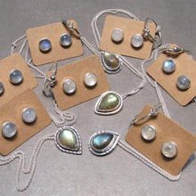 Load image into Gallery viewer, These sweet little studs feature ethically sourced rainbow moonstones set in a simple recycled silver bezel. At 9mm wide, they are the perfect size for everyday wear while still adding a flash of shimmer to your look! Solid sterling studs and surgical steel butterfly backings provide a secure fit for sensitive skin. These moondrops come in a range of colours from pearly white to twilight blue so you can pick your perfect pair!