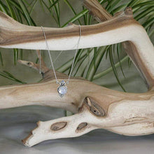 Load image into Gallery viewer, Hand-shaped silver tendrils allow this Fleur pendant to glide along its dainty oval chain. A narrow round bezel band and silver pebbles accent the violet-blue flash of the Moonstone.