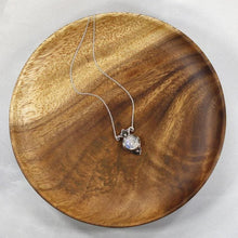 Load image into Gallery viewer, Hand-shaped silver tendrils allow this Fleur pendant to glide along its dainty oval chain. A narrow round bezel band and silver pebbles accent the violet-blue flash of the Moonstone.