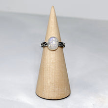 Load image into Gallery viewer, A truly one-of-a-kind piece, the Stevie features a wide textured band wrapped in a hand sculpted leafy vine crowned by a flashy crystalline Rainbow Moonstone. The black patina has been buffed back to highlight the details of this unique jewel.