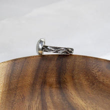 Load image into Gallery viewer, A truly one-of-a-kind piece, the Stevie features a wide textured band wrapped in a hand sculpted leafy vine crowned by a flashy crystalline Rainbow Moonstone. The black patina has been buffed back to highlight the details of this unique jewel.