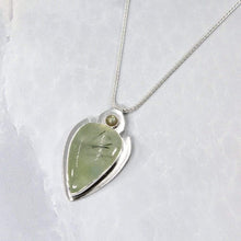 Load image into Gallery viewer, The Jeryn necklace is an absolute showstopper. Featuring a large translucent pear green Prehnite with black tourmaline inclusions, the spearhead shaped pendant is topped off with a luminous peachy green Labradorite set in a hand-texture bezel. A strong and elegant wheat chain balances the piece out and a 2” extension chain allows for neckline options.