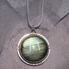 Load image into Gallery viewer, With a stunning streaked green and blue round Labradorite, the Rochelle necklace provides a lush focal point for your look. Ringed with a square-wire halo with delicate hand-carved notches and an unusual peaked bail, Rochelle is sure to be a well-loved addition to your collection.