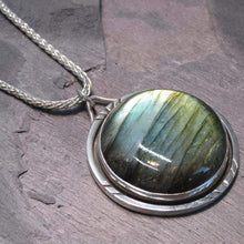Load image into Gallery viewer, With a stunning streaked green and blue round Labradorite, the Rochelle necklace provides a lush focal point for your look. Ringed with a square-wire halo with delicate hand-carved notches and an unusual peaked bail, Rochelle is sure to be a well-loved addition to your collection.