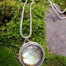 Load image into Gallery viewer, With a stunning streaked green and blue round Labradorite, the Rochelle necklace provides a lush focal point for your look. Ringed with a square-wire halo with delicate hand-carved notches and an unusual peaked bail, Rochelle is sure to be a well-loved addition to your collection.
