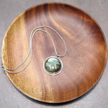 Load image into Gallery viewer, With a stunning streaked green and blue round Labradorite, the Rochelle necklace provides a lush focal point for your look. Ringed with a square-wire halo with delicate hand-carved notches and an unusual peaked bail, Rochelle is sure to be a well-loved addition to your collection.