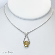 Load image into Gallery viewer, Rosecut Quartz with golden hued crystalline inclusions set in a silver bezel and suspended in an airy frame  Details:  Solid sterling silver, partially recycled  Rutilated Quartz  Pendant: 13mm x 26mm 16” long Sterling Silver chain plus 2” Extender  Lobster-claw clasp