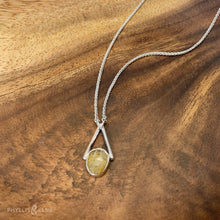 Load image into Gallery viewer, Rosecut Quartz with golden hued crystalline inclusions set in a silver bezel and suspended in an airy frame  Details:  Solid sterling silver, partially recycled  Rutilated Quartz  Pendant: 13mm x 26mm 16” long Sterling Silver chain plus 2” Extender  Lobster-claw clasp
