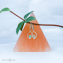 Load image into Gallery viewer, Dainty dangles with set with faceted Ethiopian opals suspended in a sterling frame. The faceted teardrop opals have stunning flashes of orange, yellow, and green depending on the light. Elegant lever-back ear hooks keep your new earrings secure with extra style.  Solid Sterling Silver, partially recycled  Natural Ethiopian Opals  Earring face - 12mm x 18mm  Sterling Lever-back ear hooks