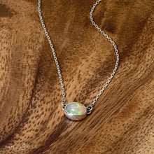 Load image into Gallery viewer, Evie brings the perfect tiny highlight to your look. The lovely Ethiopian Opal shows flashes of peach, green, and yellow and is nestled in a delicate diamond-cut sterling silver chain for extra sparkle. Solid sterling silver, partially recycled  Ethiopian Opal   Pendant 10mm X 6mm  16” long Sterling Silver chain  Lobster claw clasp