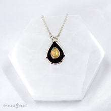 Load image into Gallery viewer, A brilliant orange and green teardrop opal is accented by a wide shadowbox and a delicately detailed border.  Details  Solid sterling silver, some recycled content  Ethiopian Opal cabochon  Pendant 13mm x 21mm  17” long Sterling Silver chain with 2" extender