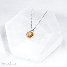 Load image into Gallery viewer, This 9mm Luna necklace features a beautiful orange Ethiopian Opal set simply in a smooth silver bezel. A a diamond cut chain adds a subtle sparkle to complete the clean, classic look you will find yourself wearing over and over.  Details  Solid sterling silver, partially recycled  Ethiopian Opal  Pendant: 9mm  16” long Sterling Silver chain   Lobster-claw clasp