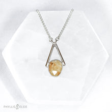 Load image into Gallery viewer, Rosecut Quartz with golden hued crystalline inclusions set in a silver bezel and suspended in an airy frame  Details:  Solid sterling silver, partially recycled  Rutilated Quartz  Pendant: 13mm x 26mm  16” long Sterling Silver chain plus 2” Extender  Lobster-claw clasp