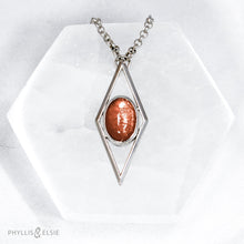 Load image into Gallery viewer, A rich orange oval Sunstone is centered in a diamond frame of polished silver. Beveled edges catch the light and highlight the stone floating in the center.  Details  Solid sterling silver, partially recycled  Sunstone  Pendant: 17mm x 41mm  18" Sterling chain plus 2" extension   Lobster claw clasp