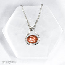 Load image into Gallery viewer, A shimmering orange Sunstone set in a silver bezel and nestled in an elegant and minimalist teardrop halo.   Details  Solid sterling silver, partially recycled  Sunstone  Pendant 17mm x 20mm  16” long Sterling Silver chain plus 2" Extension  Lobster claw clasp