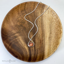 Load image into Gallery viewer, A shimmering orange Sunstone set in a silver bezel and nestled in an elegant and minimalist teardrop halo.   Solid sterling silver, partially recycled  Sunstone  Pendant 17mm x 20mm 16” long Sterling Silver chain plus 2" Extension  Lobster claw clasp