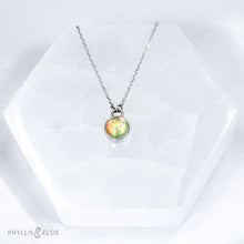 Load image into Gallery viewer, This 8mm Luna necklace features a beautiful Ethiopian Opal set simply in a smooth silver bezel. A a diamond cut chain adds a subtle sparkle to complete the clean, classic look you will find yourself wearing over and over.  Details:  Solid sterling silver, partially recycled  Ethiopian Opal  Pendant: 8mm  16” long Sterling Silver chain   Lobster-claw clasp