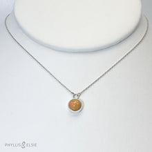 Load image into Gallery viewer, This 9mm Luna necklace features a beautiful orange Ethiopian Opal set simply in a smooth silver bezel. A a diamond cut chain adds a subtle sparkle to complete the clean, classic look you will find yourself wearing over and over.  Details:  Solid sterling silver, partially recycled  Ethiopian Opal  Pendant: 9mm  16” long Sterling Silver chain   Lobster-claw clasp