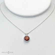 Load image into Gallery viewer, This 10mm Luna necklace features a beautiful rust colored Sunstone set simply in a smooth silver bezel. A slim oval chain completes the clean, classic look you will find yourself wearing over and over.  Details:  Solid sterling silver, partially recycled  Sunstone  Pendant: 10mm  16” long Sterling Silver chain   Lobster-claw clasp