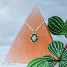 Load image into Gallery viewer, A super flashy Ethiopian Opal wrapped in a silver bezel is framed by a slim patinated shadowbox and hand carved details.   Details:  Solid sterling silver, partially recycled  Ethiopian Opal  Pendant: 10mm x 17mm  16” long Sterling Silver chain plus 2" extension  Lobster-claw clasp