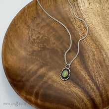 Load image into Gallery viewer, A super flashy Ethiopian Opal wrapped in a silver bezel is framed by a slim patinated shadowbox and hand carved details.   Details:  Solid sterling silver, partially recycled  Ethiopian Opal  Pendant: 10mm x 17mm  16” long Sterling Silver chain plus 2" extension  Lobster-claw clasp