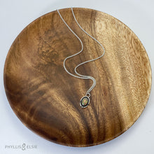 Load image into Gallery viewer, A super flashy Ethiopian Opal wrapped in a silver bezel is framed by a slim patinated shadowbox and hand carved details.   Details:  Solid sterling silver, partially recycled  Ethiopian Opal  Pendant: 10mm x 16mm 16” long Sterling Silver chain plus 2" extension  Lobster-claw clasp