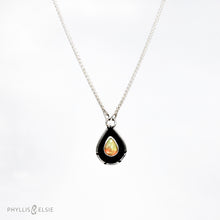 Load image into Gallery viewer, A brilliant orange and green teardrop opal is accented by a wide shadowbox and a delicately detailed border.  Details  Solid sterling silver, some recycled content  Ethiopian Opal cabochon  Pendant 13mm x 21mm  17” long Sterling Silver chain with 2" extender
