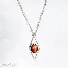 Load image into Gallery viewer, A rich orange oval Sunstone is centered in a diamond frame of polished silver. Beveled edges catch the light and highlight the stone floating in the center.  Details  Solid sterling silver, partially recycled  Sunstone  Pendant: 17mm x 41mm  18" Sterling chain plus 2" extension   Lobster claw clasp