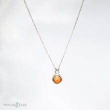 Load image into Gallery viewer, This 9mm Luna necklace features a beautiful orange Ethiopian Opal set simply in a smooth silver bezel. A a diamond cut chain adds a subtle sparkle to complete the clean, classic look you will find yourself wearing over and over.  Details  Solid sterling silver, partially recycled  Ethiopian Opal  Pendant: 9mm  16” long Sterling Silver chain   Lobster-claw clasp