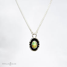 Load image into Gallery viewer, A super flashy Ethiopian Opal wrapped in a silver bezel is framed by a slim patinated shadowbox and hand carved details.   Details  Solid sterling silver, partially recycled  Ethiopian Opal  Pendant: 10mm x 17mm  16” long Sterling Silver chain plus 2" extension  Lobster-claw clasp