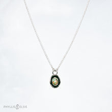 Load image into Gallery viewer, A super flashy Ethiopian Opal wrapped in a silver bezel is framed by a slim patinated shadowbox and hand carved details.   Details  Solid sterling silver, partially recycled  Ethiopian Opal  Pendant: 10mm x 16mm  16” long Sterling Silver chain plus 2" extension  Lobster-claw clasp