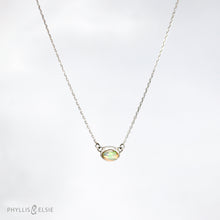 Load image into Gallery viewer, Evie brings the perfect tiny highlight to your look. The lovely Ethiopian Opal shows flashes of peach, green, and yellow and is nestled in a delicate diamond-cut sterling silver chain for extra sparkle.  Details  Solid sterling silver, partially recycled  Ethiopian Opal   Pendant 10mm X 6mm  16” long Sterling Silver chain  Lobster claw clasp