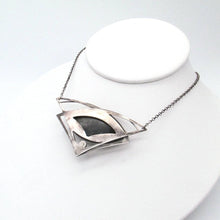 Load image into Gallery viewer, This striking necklace features a stunning deep blue and aqua labradorite marquise cabochon framed by layered silver wings and a demure jade gem. The 16” chain lets the pendant land just below the collarbone. The .925 Sterling silver surround has an oxidized and antiqued finish, giving this piece the look of an heirloom treasure with a story to tell.