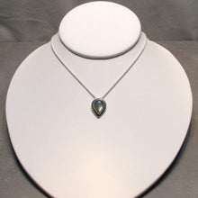 Load image into Gallery viewer, This Stella necklace features a glowing, smooth sage-green Labradorite teardop cabochon that shows glimpses of peach and aqua in bright light. Surrounded with a slightly-offset twisted halo, this pendant stands out despite its small size and soft colors.