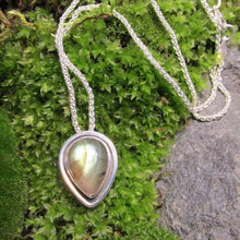 Load image into Gallery viewer, This Stella necklace features an iridescent aqua to amber Labradorite teardop cabochon surrounded by a classic halo of polished round wire. A hidden bail lets the pendant float on the chain with no visual clutter. Simultaneously minimal and unusual, this Stella necklace is the perfect finishing touch to a wide range of looks.