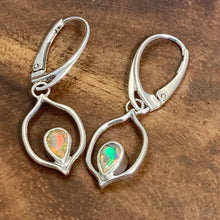 Load image into Gallery viewer, Dainty dangles with set with faceted Ethiopian opals suspended in a sterling frame. The faceted teardrop opals have stunning flashes of orange, yellow, and green depending on the light. Elegant lever-back ear hooks keep your new earrings secure with extra style.  Solid Sterling Silver, partially recycled  Natural Ethiopian Opals  Earring face - 12mm x 18mm  Sterling Lever-back ear hooks