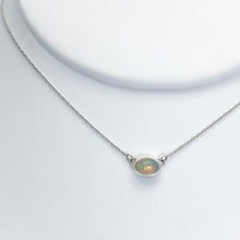 Load image into Gallery viewer, Evie brings the perfect tiny highlight to your look. The lovely Ethiopian Opal shows flashes of peach, green, and yellow and is nestled in a delicate diamond-cut sterling silver chain for extra sparkle. Solid sterling silver, partially recycled  Ethiopian Opal   Pendant 10mm X 6mm  16” long Sterling Silver chain  Lobster claw clasp