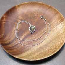 Load image into Gallery viewer, This Stella necklace features an iridescent aqua to amber Labradorite teardop cabochon surrounded by a classic halo of polished round wire. A hidden bail lets the pendant float on the chain with no visual clutter. Simultaneously minimal and unusual, this Stella necklace is the perfect finishing touch to a wide range of looks.